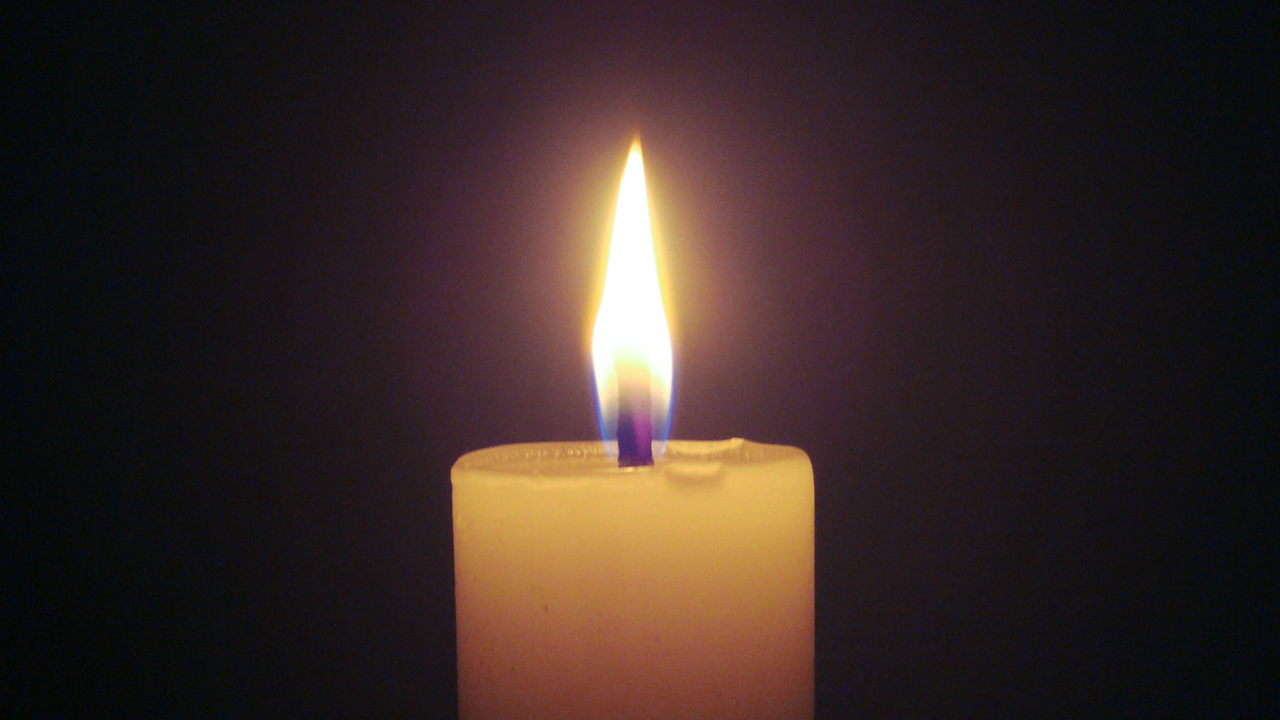 Brennende Kerze im Dunkel